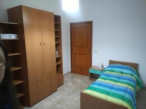 1 dormitorio con 1 cama y armario de madera en B&B La Dea Maja en Fara Filiorum Petri