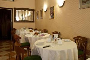un comedor con mesas y sillas con mantel blanco en Hotel Florida en Venecia