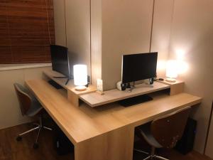 un escritorio con dos monitores y dos lámparas. en 菓菓輕旅 en Puli