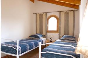 2 camas en una habitación con ventana en Villa de 4 chambres avec piscine privee terrasse amenagee et wifi a Breil sur Roya, en Breil-sur-Roya
