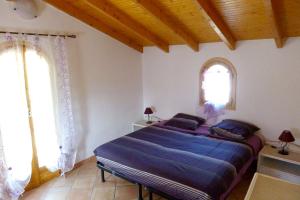 um quarto com uma cama com lençóis azuis e duas janelas em Villa de 4 chambres avec piscine privee terrasse amenagee et wifi a Breil sur Roya em Breil-sur-Roya