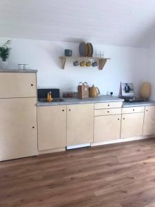 cocina con armarios blancos y suelo de madera en Castledarcy Glamping en Lahinch