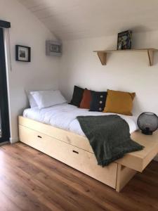 1 dormitorio con cama de madera y almohadas en Castledarcy Glamping, en Lahinch