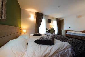 a bedroom with a large bed with two pillows on it at Hotel Vedig in Santa Caterina Valfurva