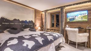 sypialnia z łóżkiem i telewizorem na ścianie w obiekcie Le Chalet de l'Atelier - Le Nord w mieście Champéry
