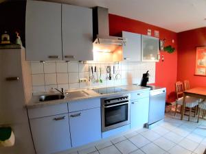a kitchen with white appliances and red walls at Twistesee Ferienwohnung in Bad Arolsen
