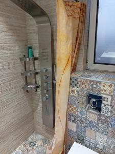 a shower in a bathroom with a wall with a window at Bright apartment at a great location in Sofia