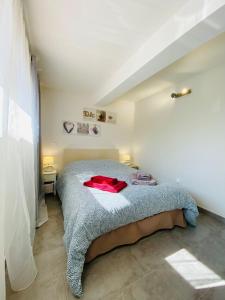 een slaapkamer met een bed met een rode jas erop bij Appartement Sol y Mar in Saint-Aygulf