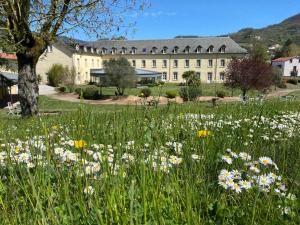 un campo de flores frente a un edificio en Le 1837, en Saint-Affrique