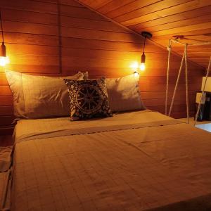 a bedroom with a bed with two lights on it at Loft encantador D - 8 km de Floripa in São José
