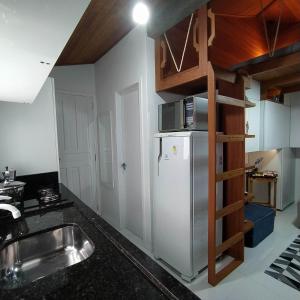 a kitchen with a sink and a refrigerator at Loft encantador D - 8 km de Floripa in São José