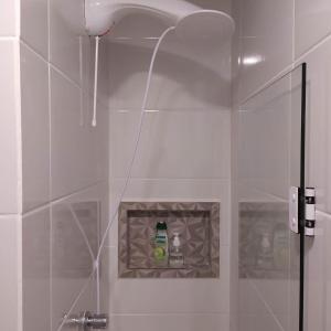 a shower with a glass door with a bottle of soap at Loft encantador D - 8 km de Floripa in São José +18 photos