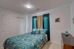 a bedroom with a bed with a blue comforter at NEWLY RENOVATED home located in the heart of ABQ in Albuquerque