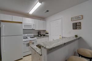 uma cozinha com armários brancos e um frigorífico branco em NEWLY RENOVATED home located in the heart of ABQ em Albuquerque