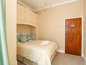 a bedroom with a bed and a wooden door at Sandpiper Court in Great Yarmouth