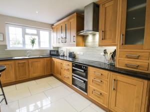 a kitchen with wooden cabinets and black counter tops at 18 High Street in Northallerton