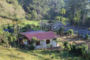 una pequeña casa con techo rojo en un campo en Casa Colibrí, en La Suiza