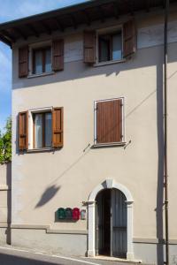 a white house with wooden windows and a door at Palazzina Gelsomino in Desenzano del Garda
