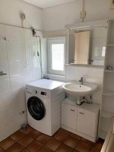 een badkamer met een wasmachine en een wastafel bij Kustverhuur, Park Schoneveld, Zeester 68 in Breskens