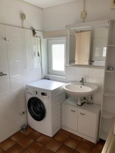 Un baño con lavadora y lavabo. en Kustverhuur, Park Schoneveld, Zeester 68, en Breskens