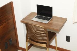 a laptop computer sitting on top of a wooden desk at Hospedaria De Maria in Salvador