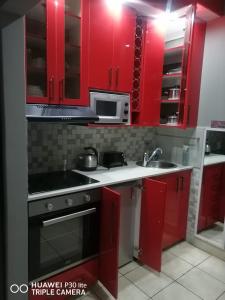 a red kitchen with a sink and a microwave at The Penthouse in Port Edward
