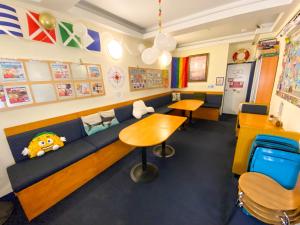 a classroom with a couch and a table and chairs at ITH Pacific Tradewinds Hostel in San Francisco