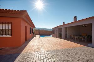 un patio de una casa con el sol en el cielo en Cuencaloft Villa del Tío Tomarro, en Villalba de la Sierra