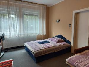 una camera da letto con un letto e una finestra di Sétány Apartmanház Fonyód a Fonyód