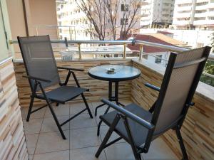 two chairs and a table on a balcony at Sunset Apartment in Shëngjin