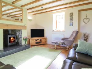 a living room with a couch and a fireplace at Tyn Llwyn in Llangollen