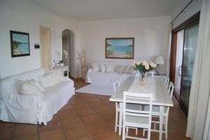 een woonkamer met een witte bank en een tafel bij Case Della Marina in Porto Cervo