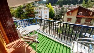 een balkon met een tafel en stoelen en uitzicht bij Armonia 13 - Pieno Centro in Roccaraso