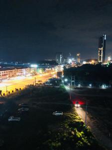 Una ciudad de noche con coches estacionados en un estacionamiento en Knightbrides the ocean Sriracha, Special rate for monthly rent, en Si Racha