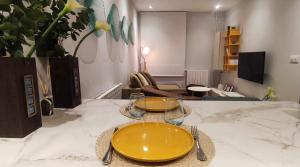 a table with two yellow plates on top of it at Apartamento Dúplex Estación Manzaneda in Ourense