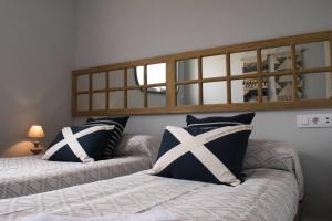 1 dormitorio con 2 camas y espejo en la pared en Apartamento Dúplex Estación Manzaneda, en Ourense