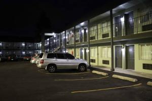 un coche aparcado en un aparcamiento frente a un edificio en Tiki Lodge Motel, en Spokane