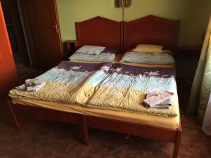 a bed with a wooden frame with two twin beds at Fehérló Vendégház & Restaurant in Bük