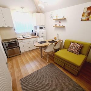 kuchnia ze stołem i zieloną kanapą w pokoju w obiekcie Cozy Studio Apartment Tian in Zagreb w Zagrzebiu +26 zdjęć