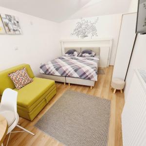 a small bedroom with a bed and a chair at Cozy Studio Apartment Tian in Zagreb in Zagreb