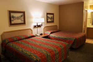 pokój hotelowy z 2 łóżkami i lampą w obiekcie Tiki Lodge Motel w mieście Spokane