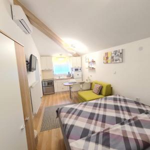 een kleine kamer met een bed en een keuken bij Cozy Studio Apartment Tian in Zagreb in Zagreb