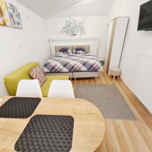 een slaapkamer met een bed en een tafel en stoelen bij Cozy Studio Apartment Tian in Zagreb in Zagreb
