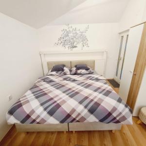 een slaapkamer met een bed met een geruite deken bij Cozy Studio Apartment Tian in Zagreb in Zagreb