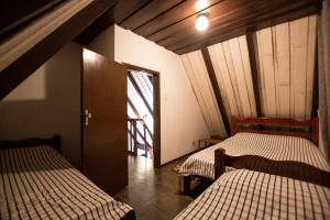 a room with two beds and a door with a window at Chalés da Cuesta in Pardinho +85 photos