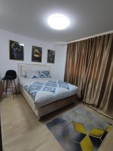 1 dormitorio con cama, ventana y taburete en Identity By Nights & Smiles, en Tuzla
