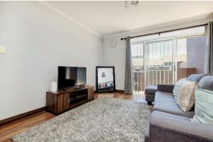 a living room with a couch and a flat screen tv at The Resting Nest in Midrand
