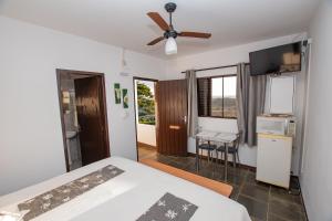 a bedroom with a bed and a ceiling fan at Chalés da Cuesta in Pardinho