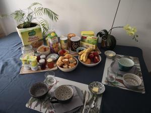 una mesa cubierta con tazones de alimentos y otros alimentos en Emel b&b, en Laville-aux-Bois