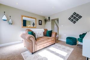 a living room with a couch and a mirror at Castle Views cottage in historic village & woodfired hot tub in Rhuddlan